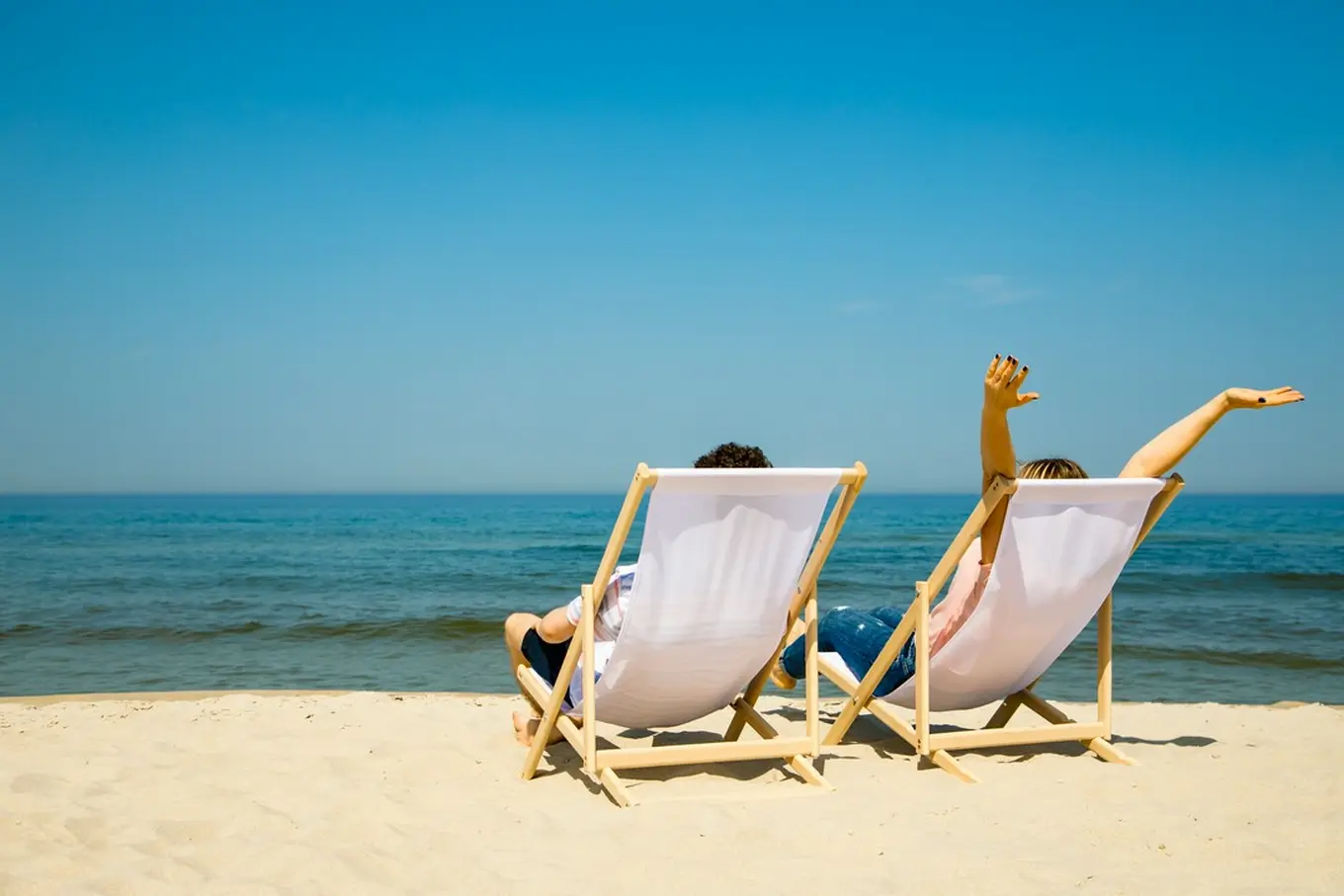 kobieta i mężczyzna na leżakach plażowych